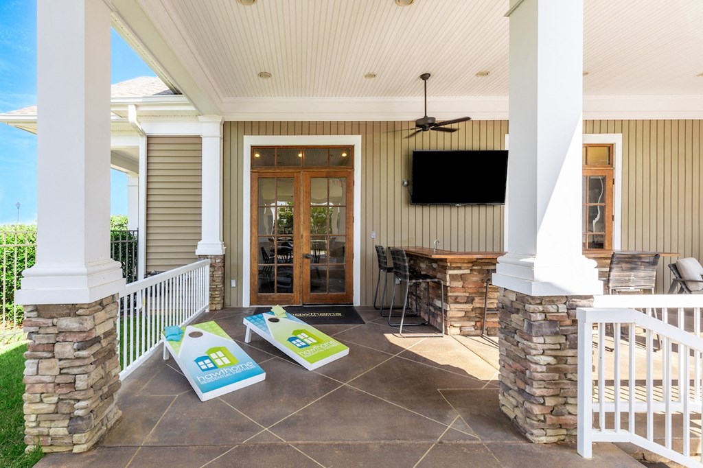 a covered patio with a tv and a table and chairs