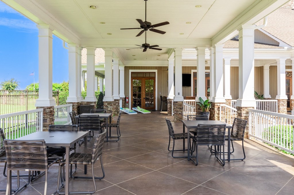 a patio with tables and chairs and a ceiling fan