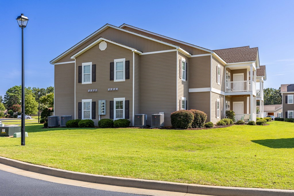 a large brown house with a lawn in front of it