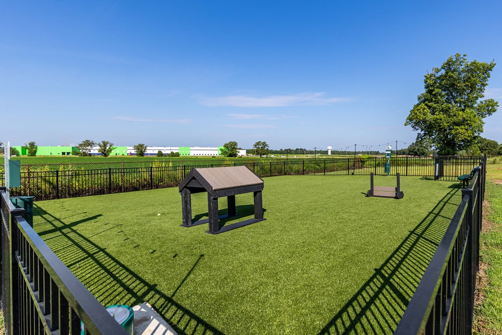 a dog park with a picnic table in the middle of the grass