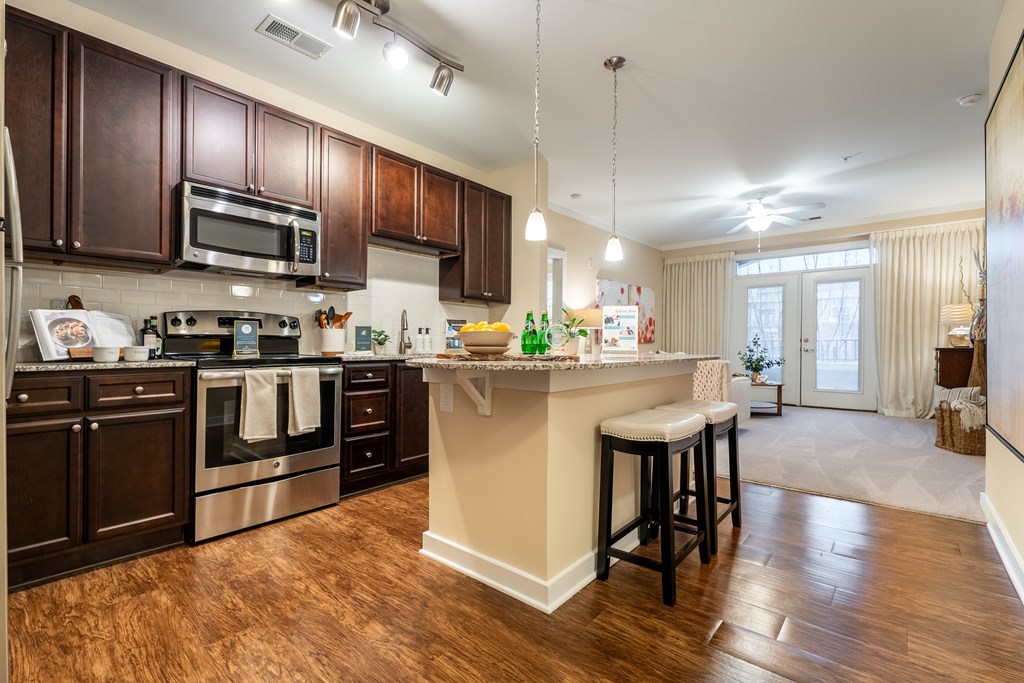 A kitchen with dark brown cabinets and a white island.