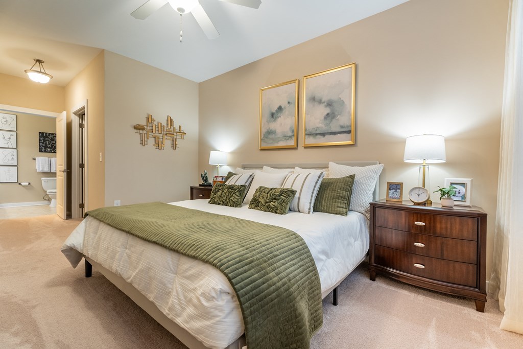 A bedroom with a large bed and a ceiling fan.