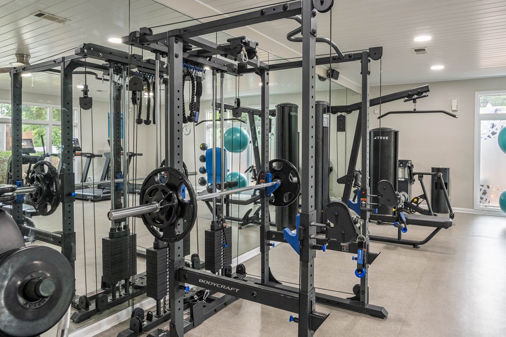 A gym with a variety of equipment including weight machines and free weights.