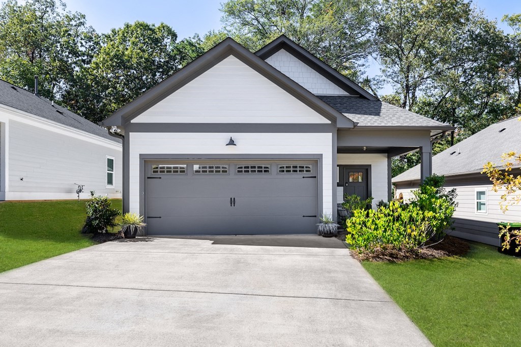 A two-story house with a garage door and a driveway.
