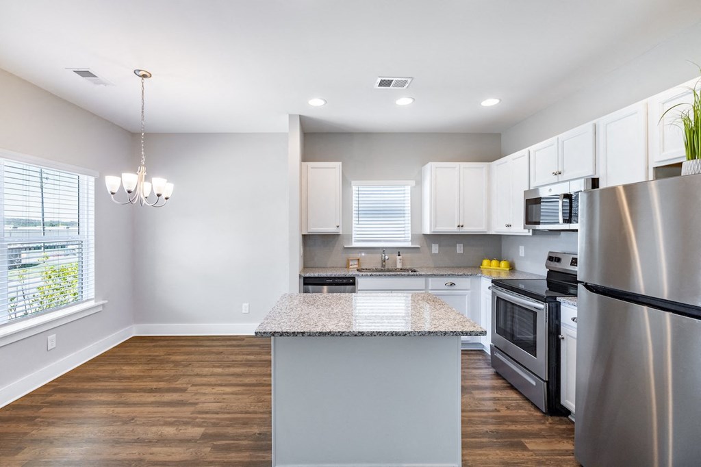 A kitchen with a granite countertop and stainless steel appliances.