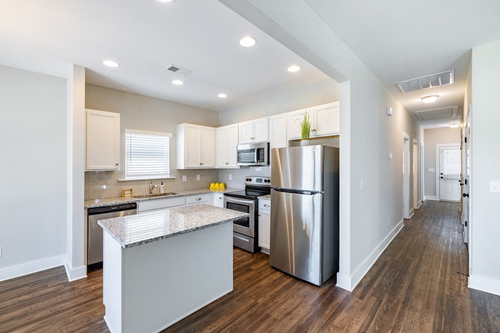 A modern kitchen with stainless steel appliances and wooden floors.