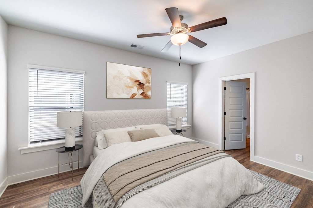 A bedroom with a large bed and a ceiling fan.
