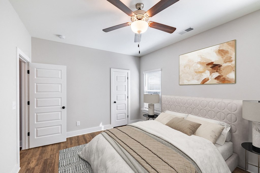 A bedroom with a large bed and a ceiling fan.