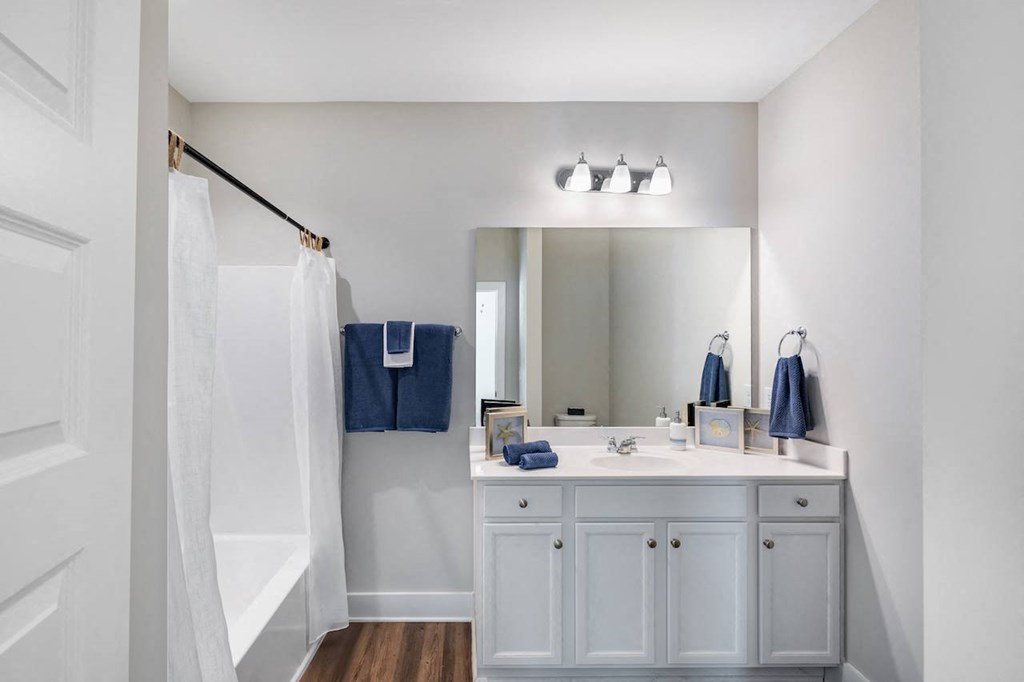 A white bathroom with a white sink and a white door.