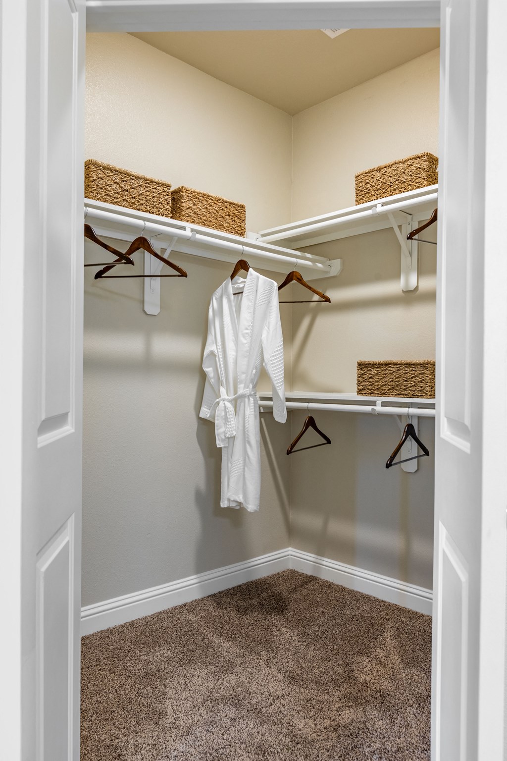 a walk in closet with a robe and hangers