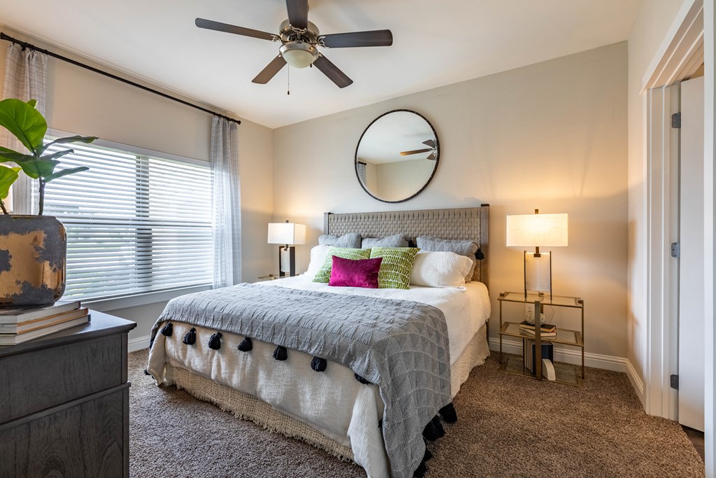 a bedroom with a large bed and a ceiling fan