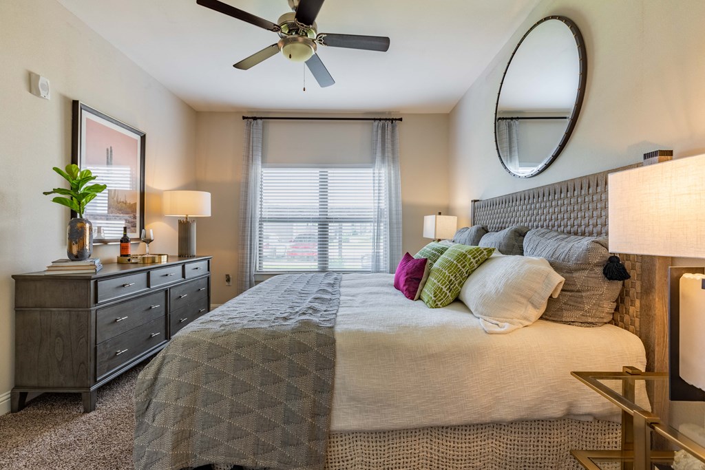 a bedroom with a large bed and a ceiling fan