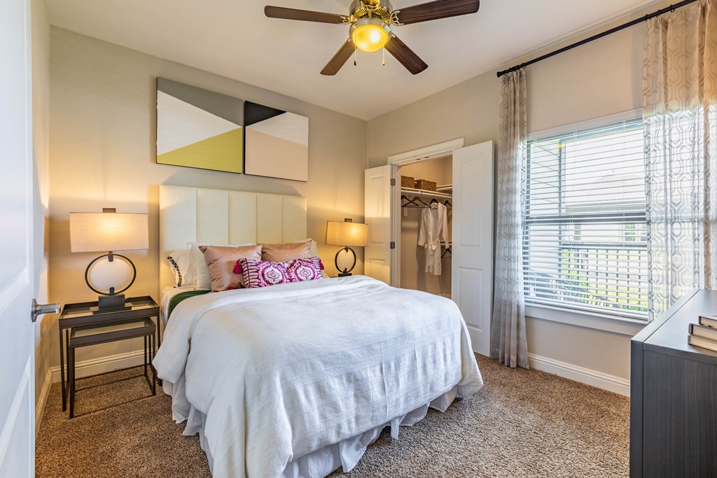 a bedroom with a large bed and a ceiling fan