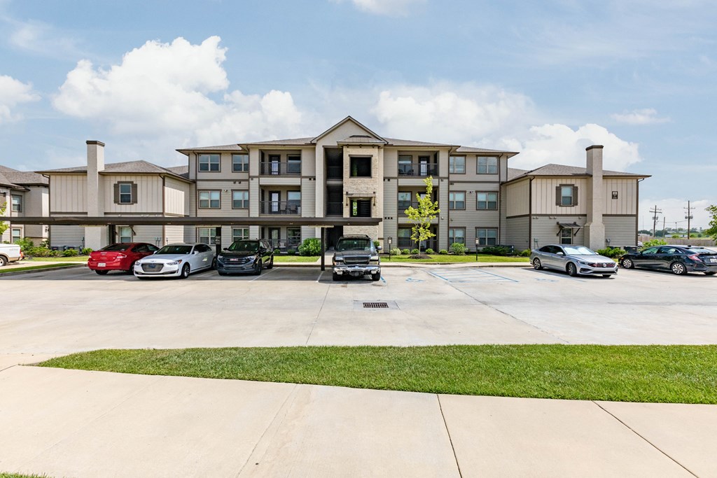 a large apartment building with cars parked in front of it