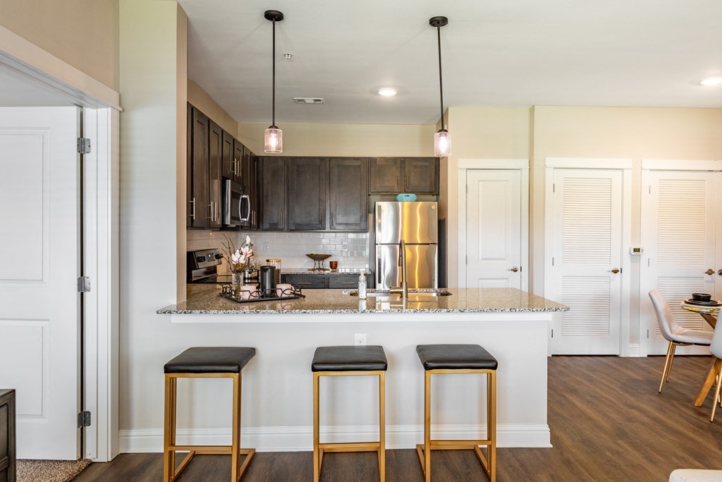 a kitchen with a counter top with three stools