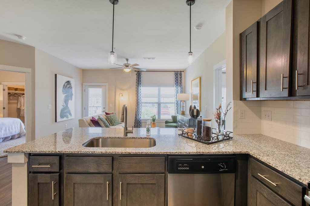 an open kitchen and living room with a sink and counter top