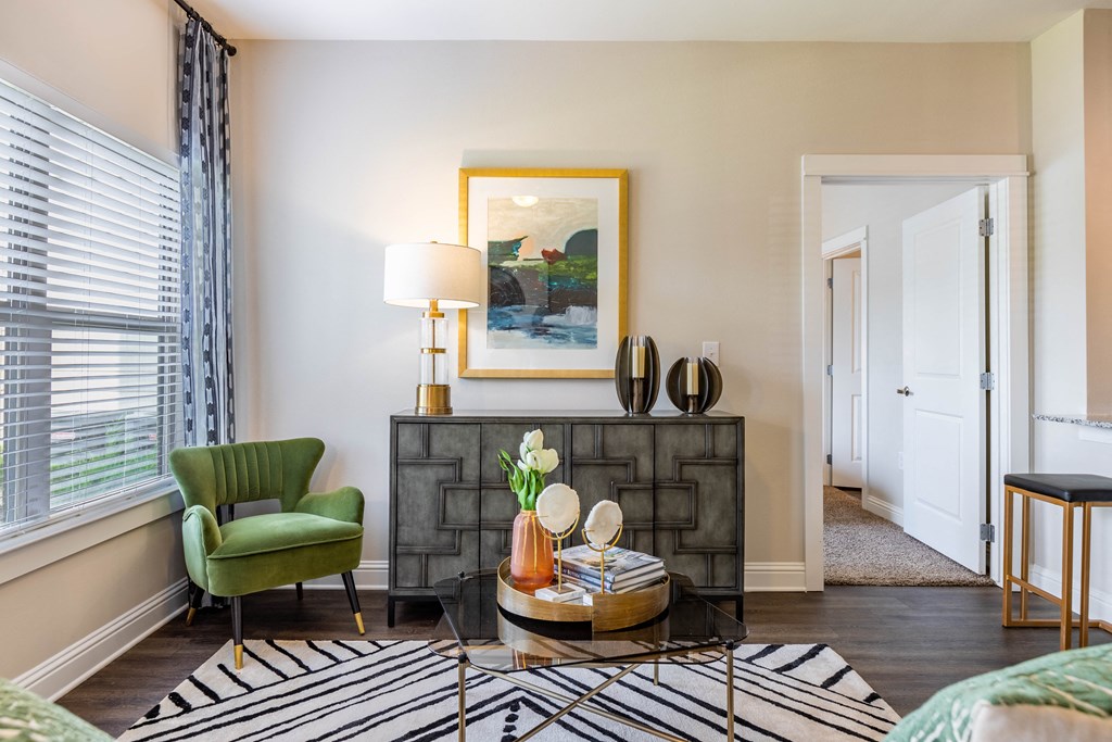 a living room with a fireplace and a green chair and a table