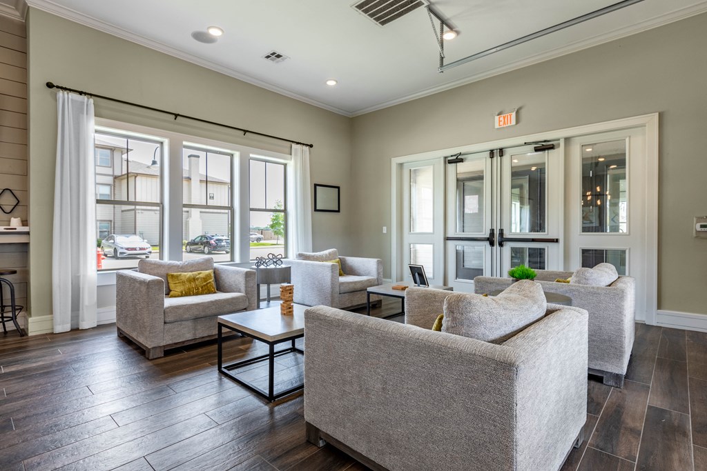 a living room with couches and chairs and windows