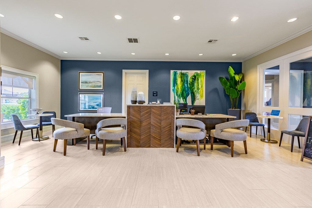 a lobby with tables and chairs and a reception desk