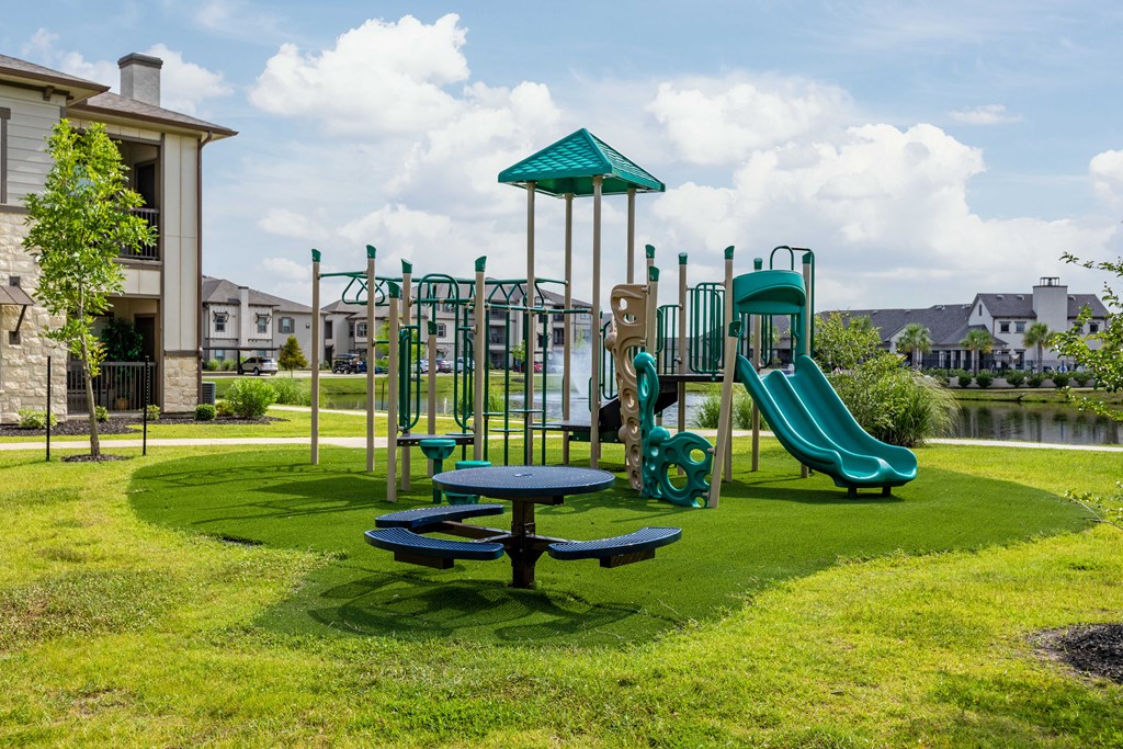 a playground with a picnic table and slides in a park