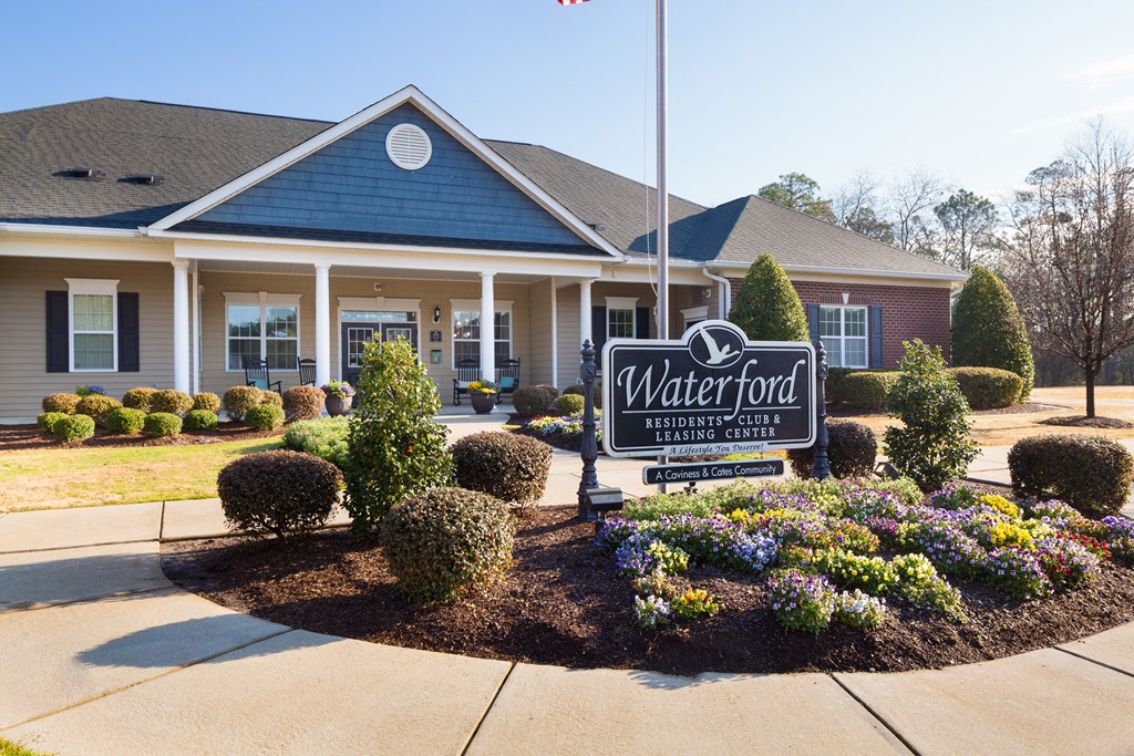 A sign for Waterford Residential Club in front of a building.