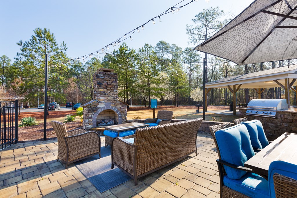 A patio with a table and chairs and a fireplace.