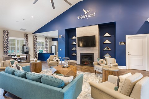 A living room with a blue couch and a fireplace.