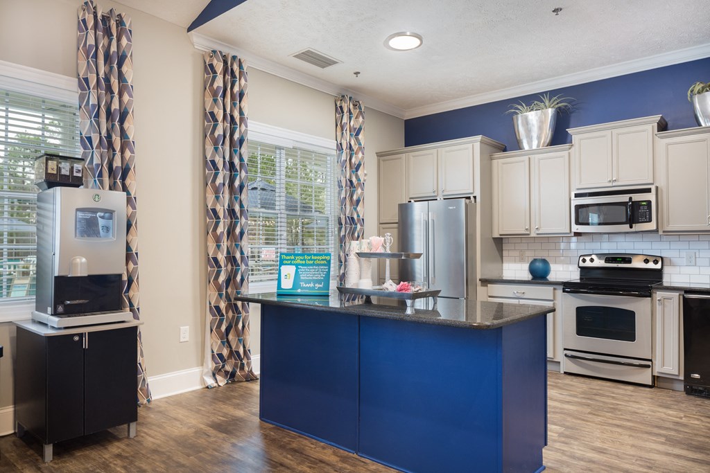 A kitchen with a blue island and white cabinets.