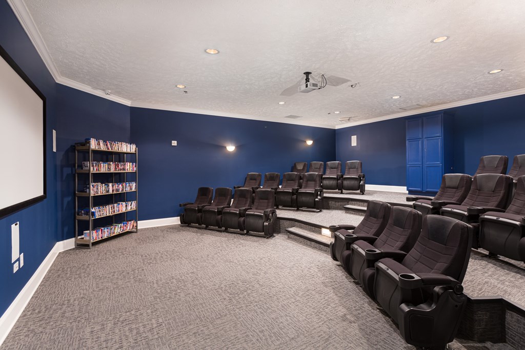 A room with a carpeted floor and a row of black chairs.