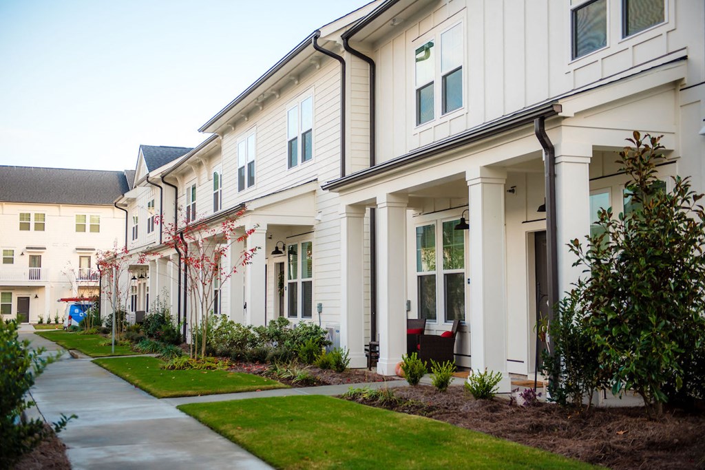 a row of townhomes with a sidewalk in front of them
