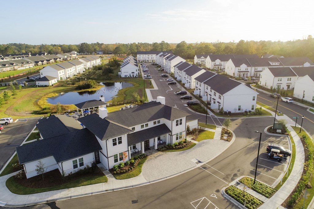 arial view of a neighborhood with houses and a pond