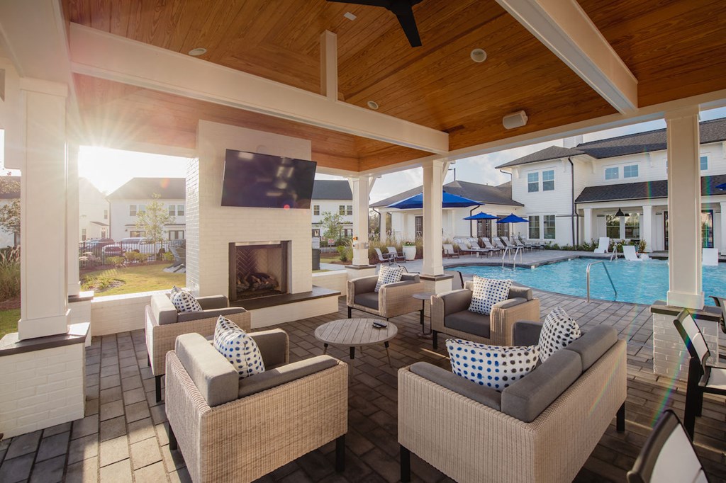 a covered patio with a fireplace and wicker furniture