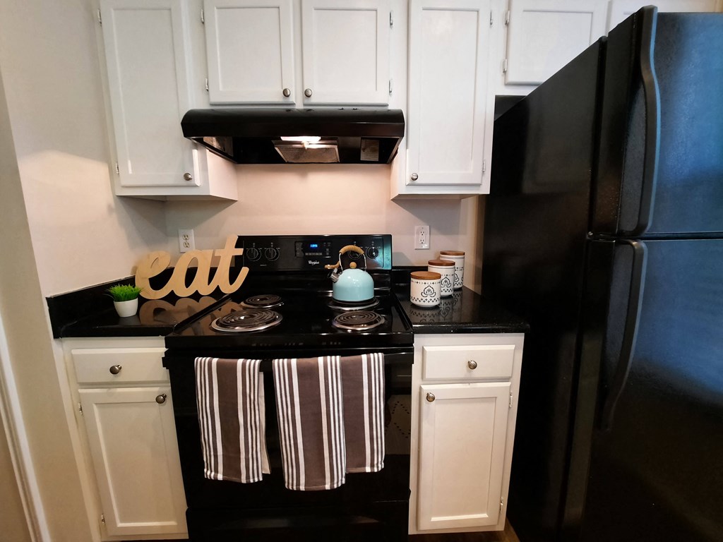 a small kitchen with black appliances and white cabinets