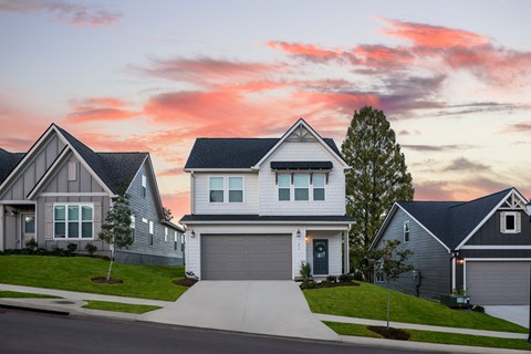 a house on a street with a sunset in the background