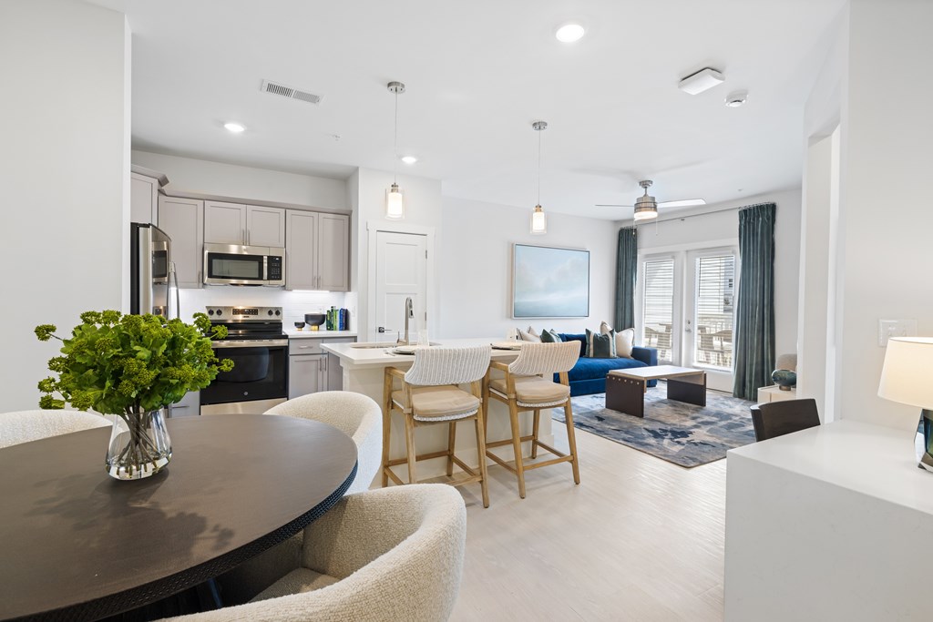 A modern kitchen with a dining table and chairs at Parker Apartments in Raleigh, NC.