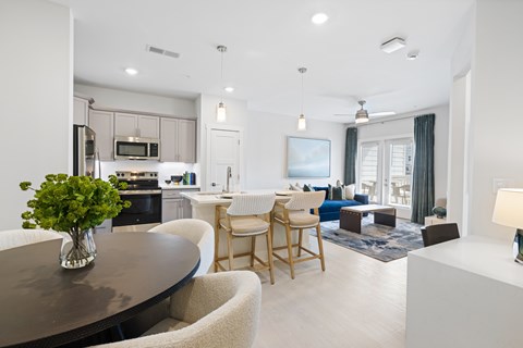 A modern kitchen with a dining table and chairs at Parker Apartments in Raleigh, NC.