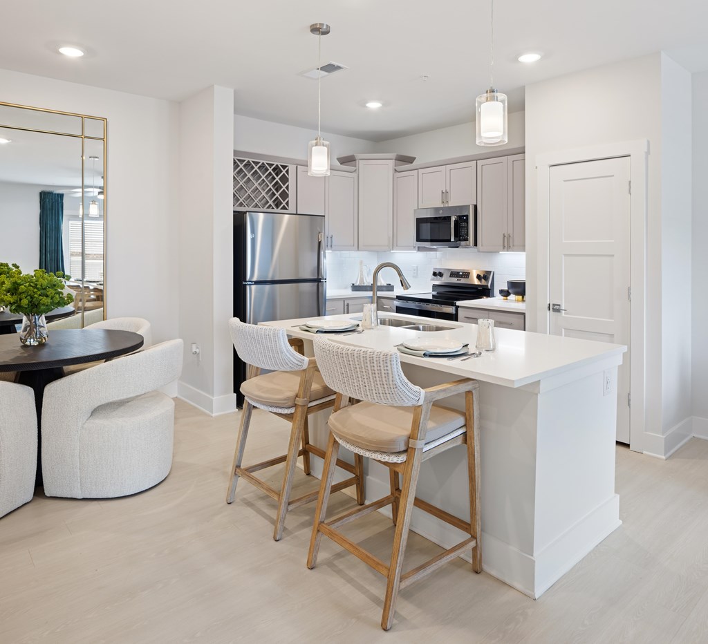 A modern kitchen with white cabinets and a large island at Parker Apartments in Raleigh, NC.