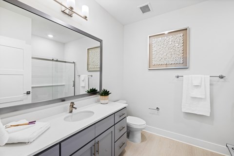 A bathroom with a white countertop and a white toilet at Parker Apartments in Raleigh, NC.