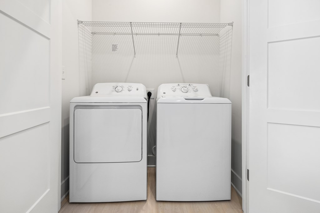 Two white front loading washing machines in a laundry room at Parker Apartments in Raleigh, NC.