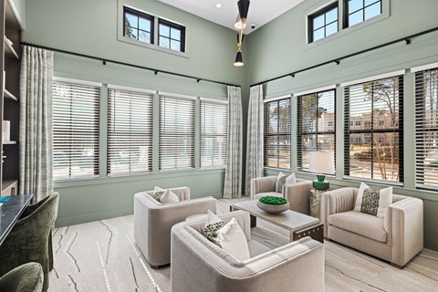 A clubhouse with a green wall and a large window with blinds at Parker Apartments in Raleigh, NC..