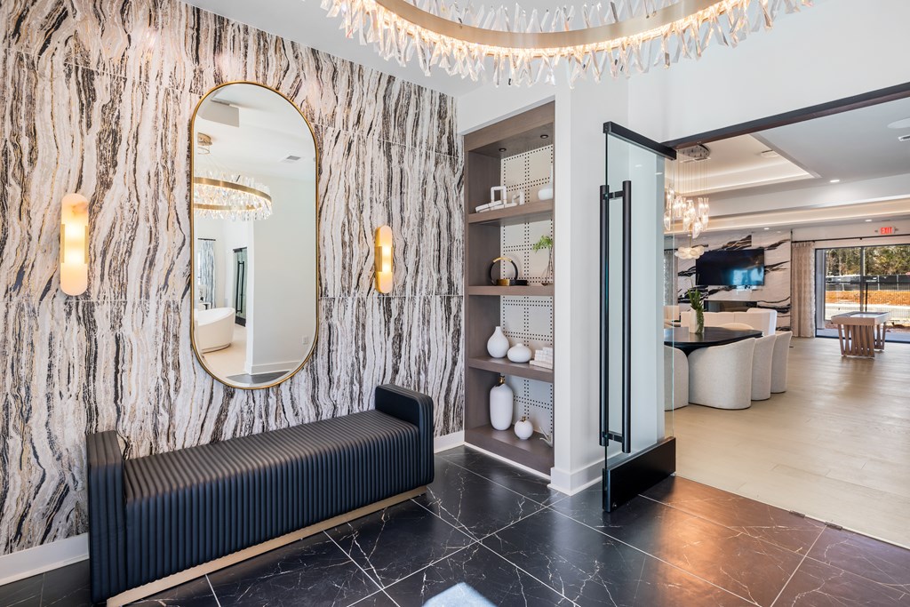 A black and white marbled wall with a mirror and lights above it at Parker Apartments in Raleigh, NC.
