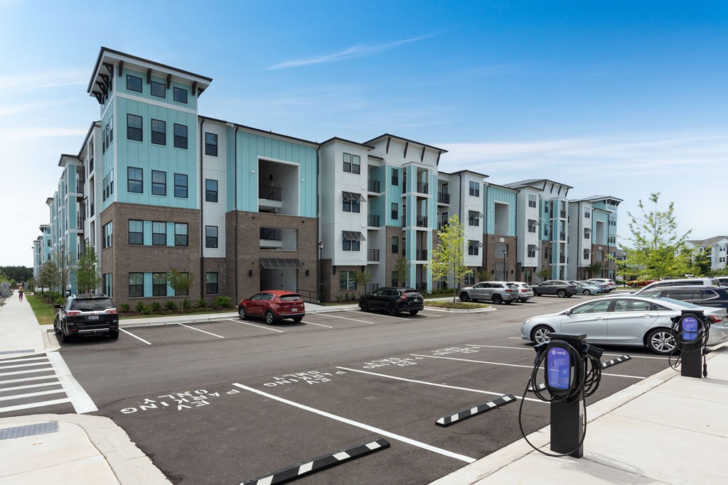 a parking lot with cars parked in front of an apartment building