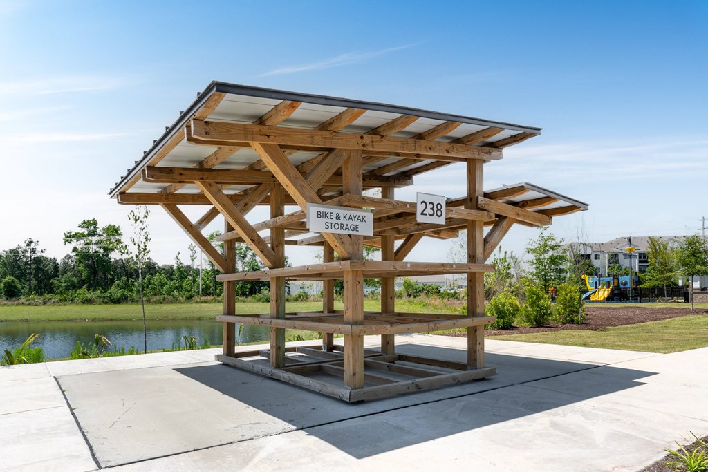 a large wooden structure with a roof on a sidewalk