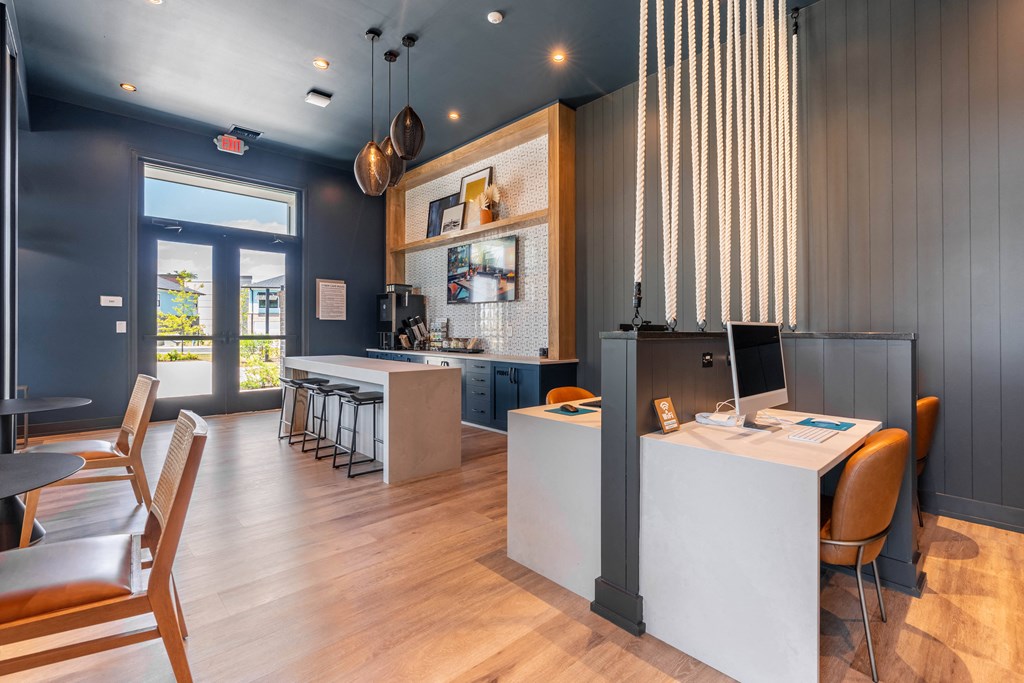 a conference room with tables and chairs and a desk with a computer