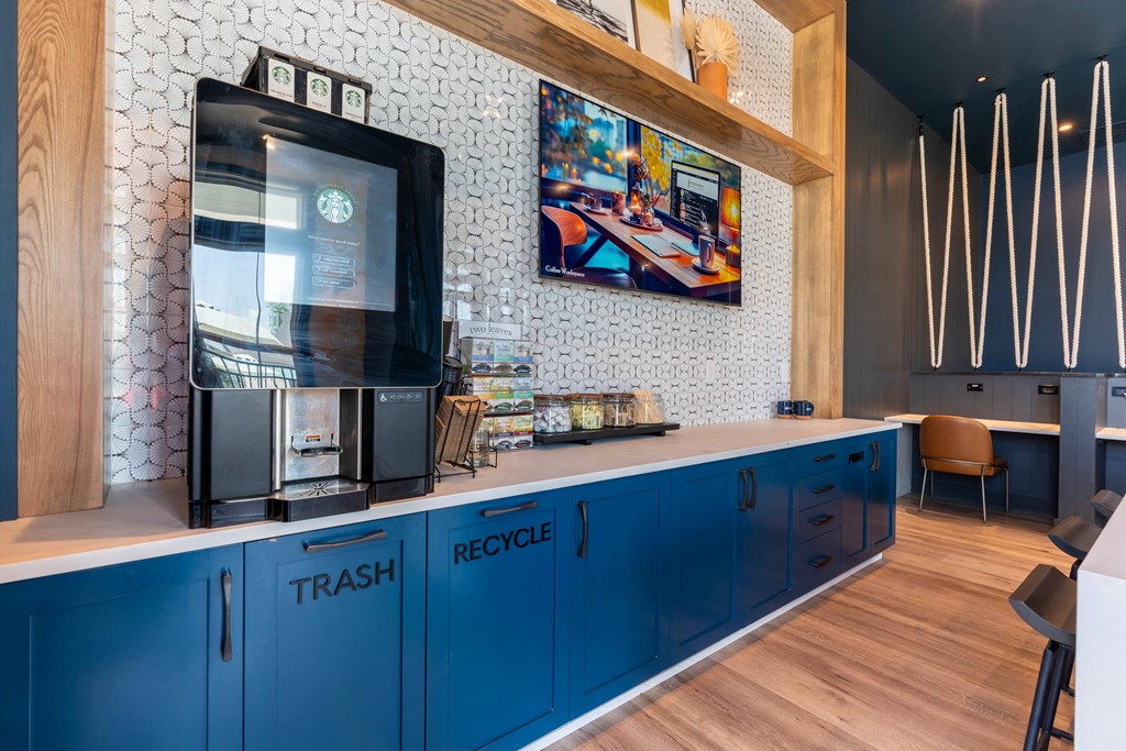a kitchen with blue cabinets and a large tv on the wall