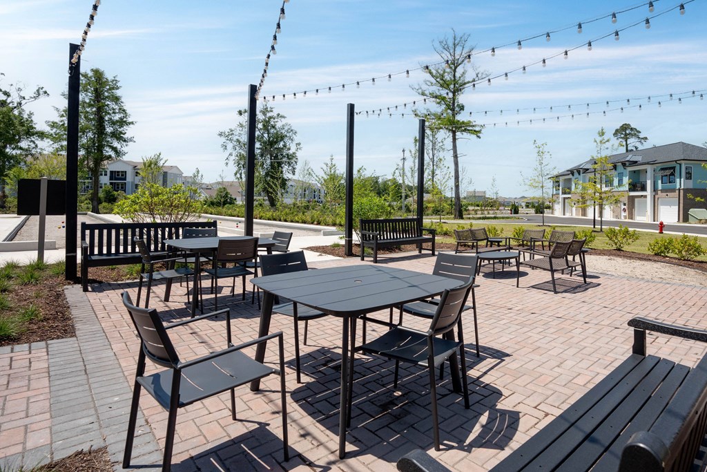 a patio with tables and chairs on a sunny day