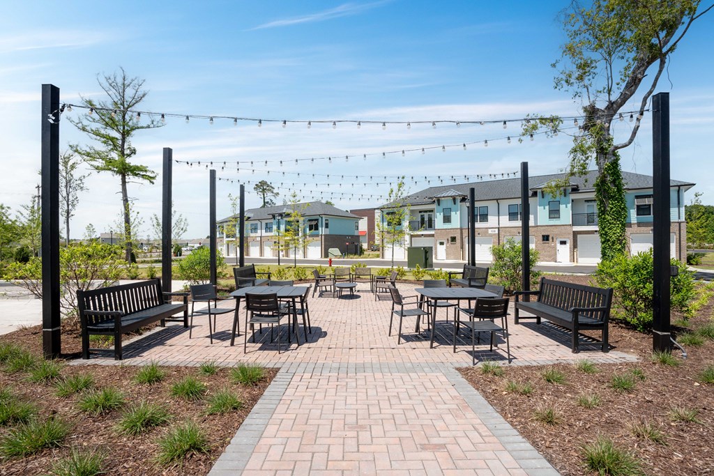 an outdoor patio with tables and chairs and buildings in the background