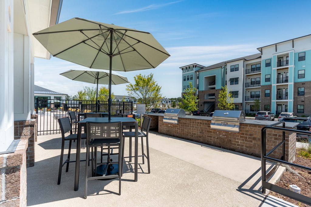 a patio with tables and umbrellas at aria on the strip apartments