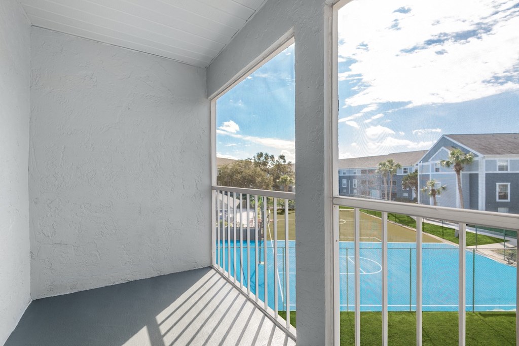 a balcony with a view of a pool and a building in the background