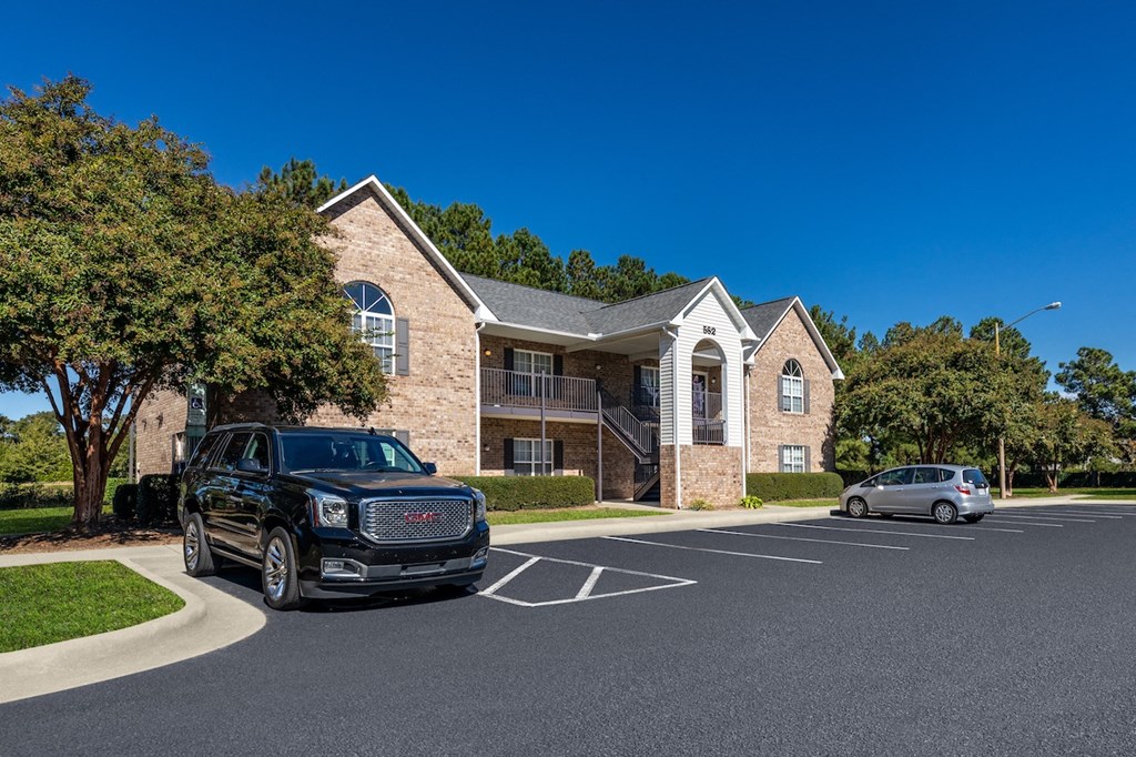 A black SUV is parked in a parking lot in front of a building.